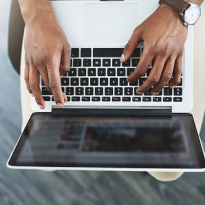 Hands typing on a laptop