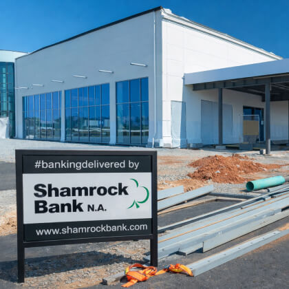A building under construction with a "Shamrock Bank" sign in front